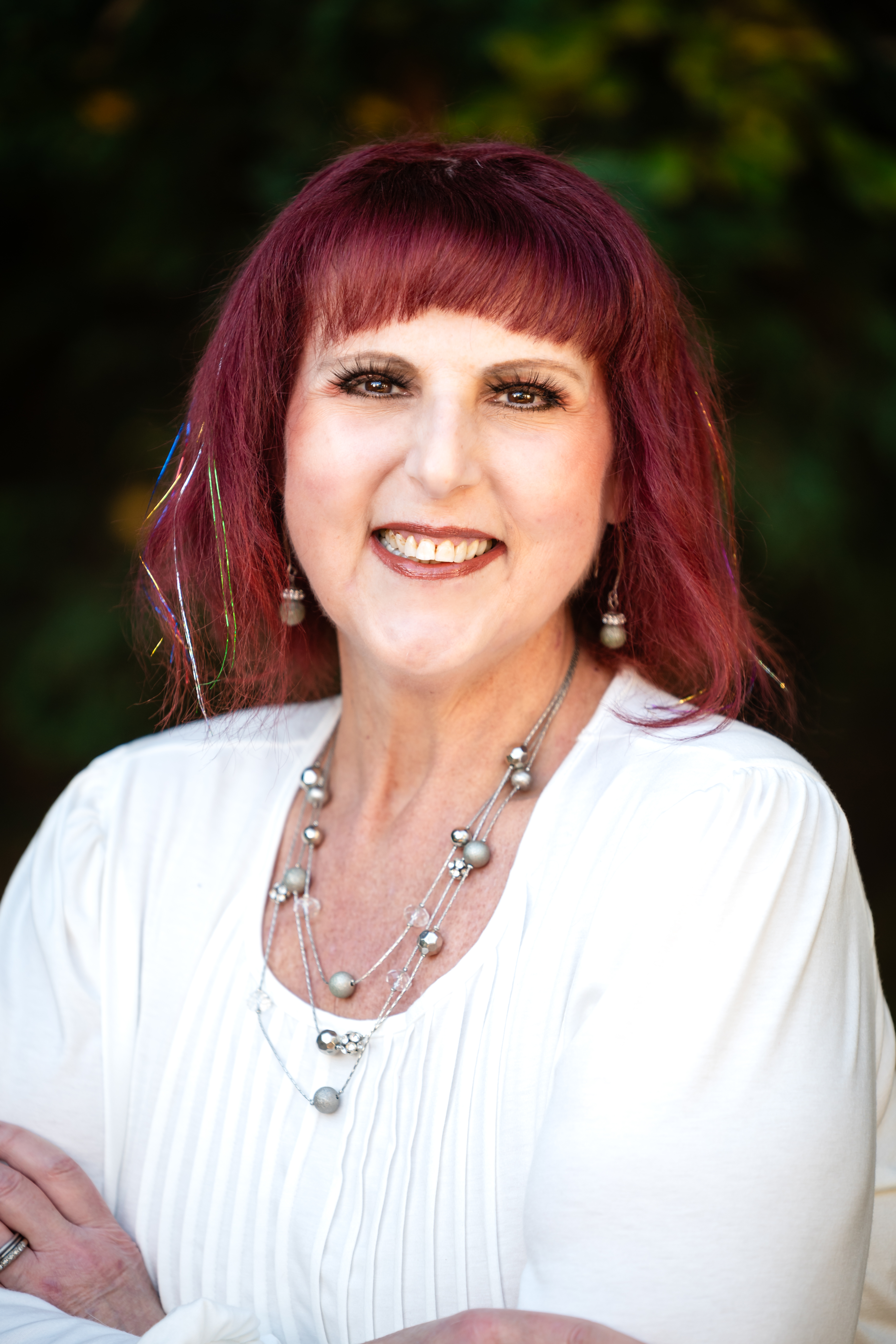 Headshot of Erika Montgomery in a white blouse with silver jewelry